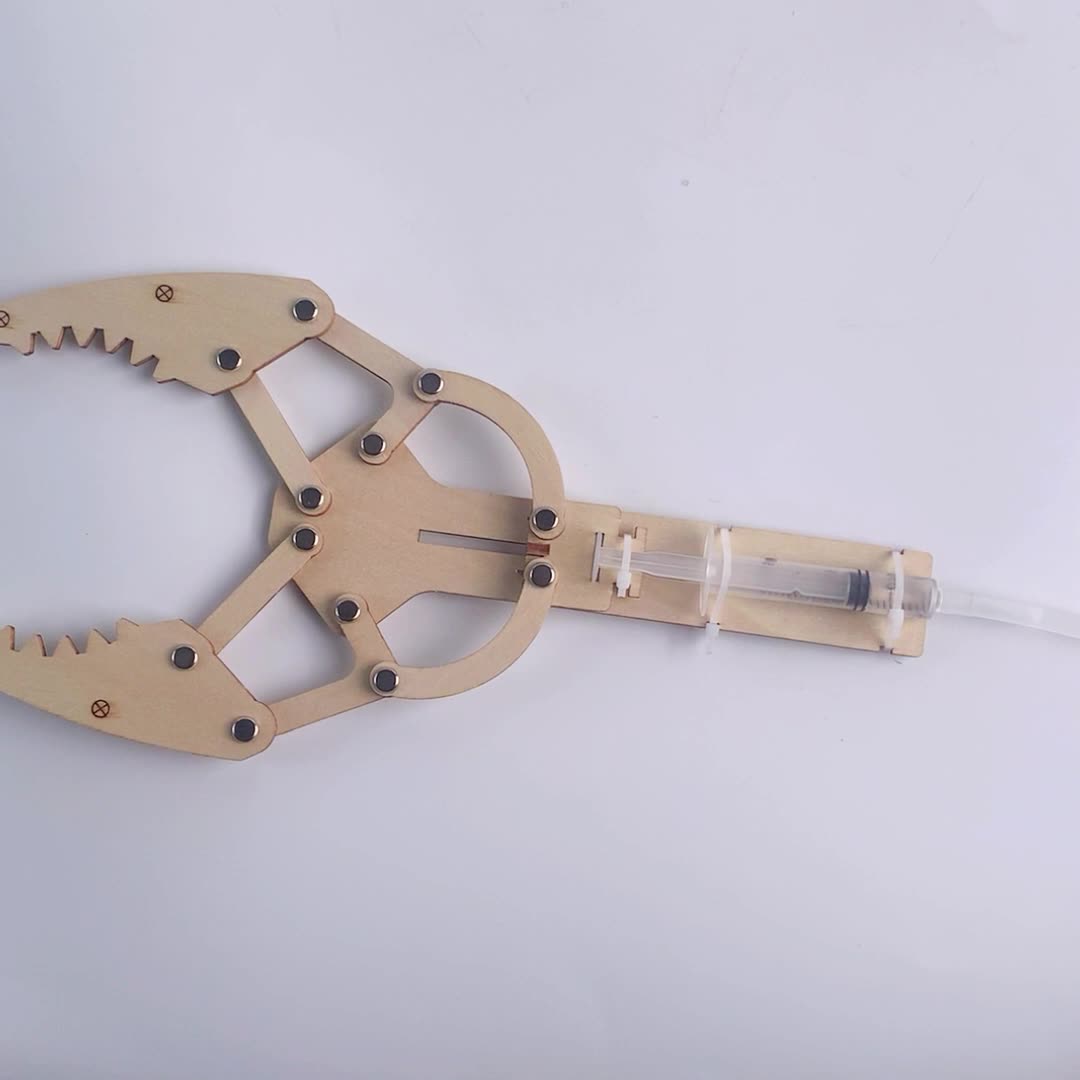 Detailed view of the completed wooden hydraulic arm with syringes and tubing.