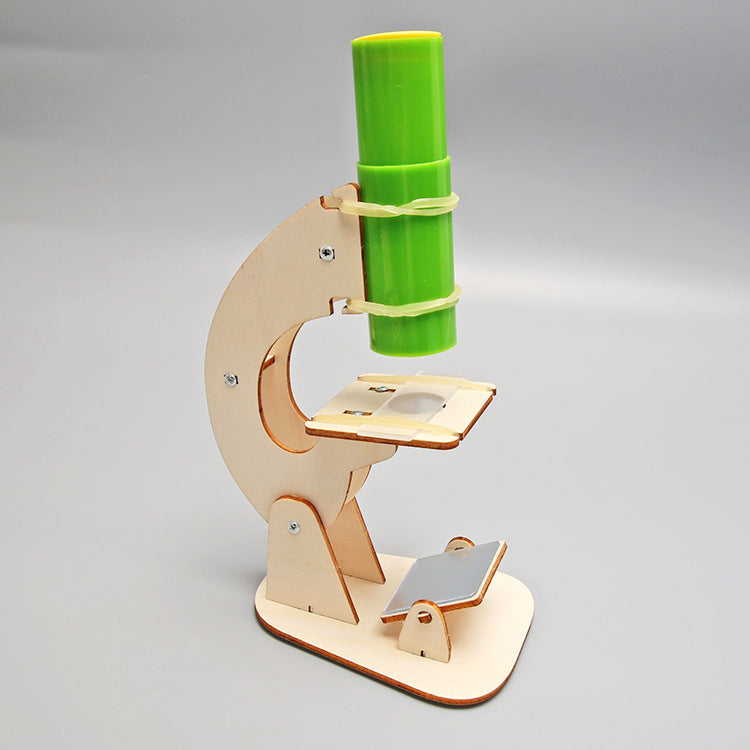 Close-up of wooden parts and lenses included in the DIY microscope science kit.