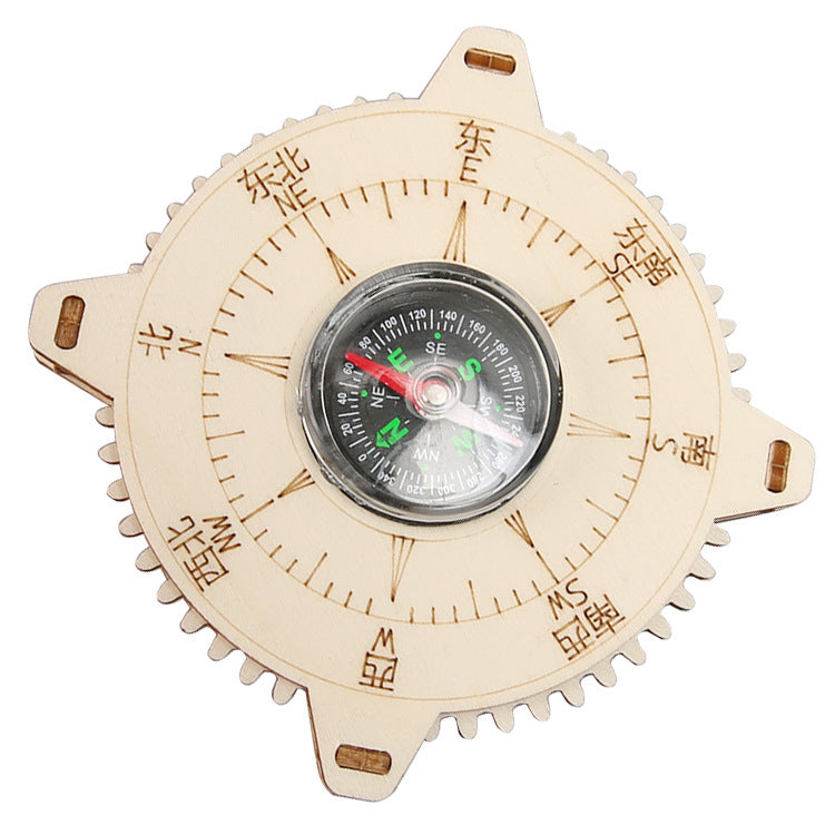 The fully assembled DIY wooden compass, a functional educational toy, displayed on a wooden surface.