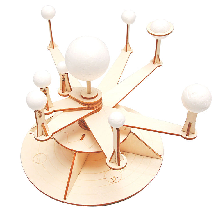 Close-up view of DIY Orrery Solar System Kit assembly process, showing interlocking wooden parts