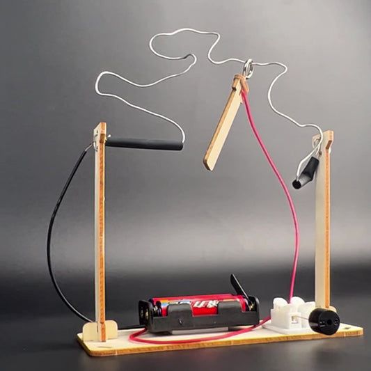 Completed DIY CrossFire Kit, an electromagnetic maze game with a wavy metal wire, wooden stand, and battery box, ideal for kids' science projects.