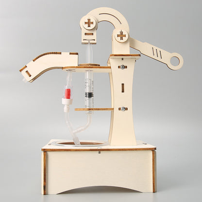 Close-up of the assembled wooden water pump mechanism, highlighting the syringes and tubing.