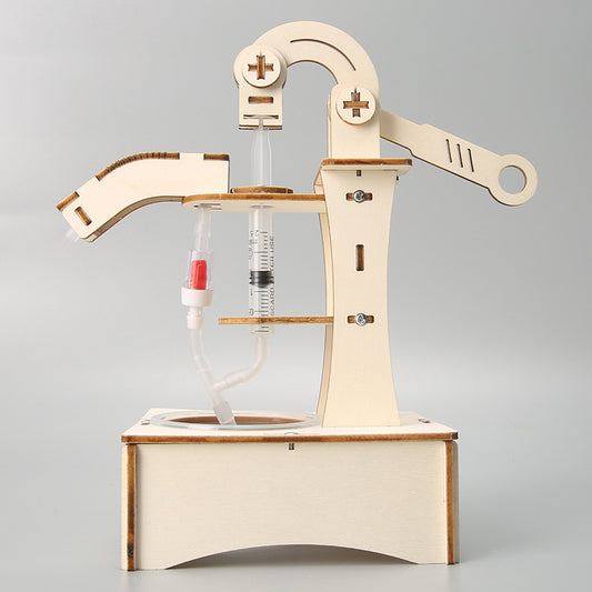 Close-up of the assembled wooden water pump mechanism, highlighting the syringes and tubing.