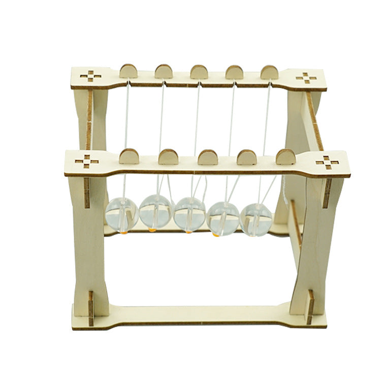 Close-up of the assembled DIY Newton's Cradle showing the suspended acrylic spheres and the connecting strings on the wooden frame. Demonstrating momentum.