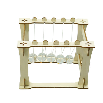 Close-up of the assembled DIY Newton's Cradle showing the suspended acrylic spheres and the connecting strings on the wooden frame. Demonstrating momentum.