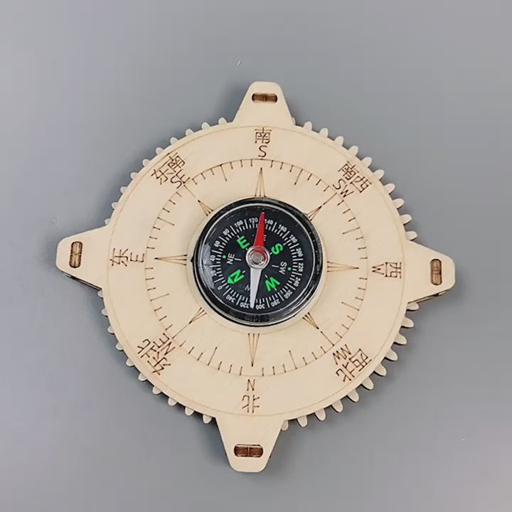A child's hands assembling a DIY wooden compass kit, showing the educational STEM experience. The compass features laser-cut wooden parts and a real magnetic compass.