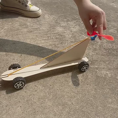 DIY Rubber Band Powered Car Kit in action, showcasing its simple design and movement powered by a rubber band.