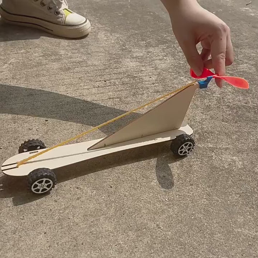 DIY Rubber Band Powered Car Kit in action, showcasing its simple design and movement powered by a rubber band.